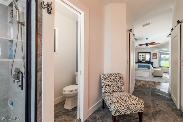 bathroom featuring ceiling fan, toilet, and a shower with shower door