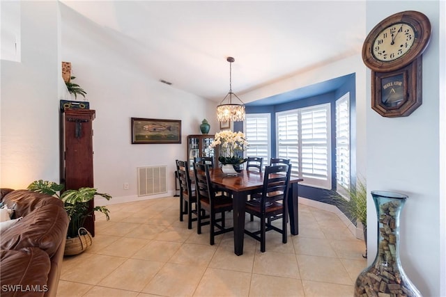 tiled dining room with an inviting chandelier and vaulted ceiling