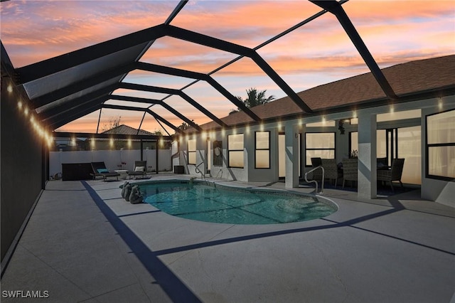 pool at dusk featuring glass enclosure, a fenced in pool, and a patio