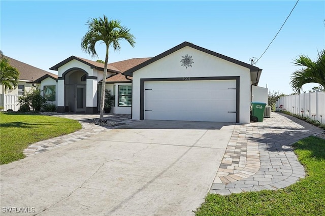 ranch-style home with driveway, an attached garage, fence, a front lawn, and stucco siding