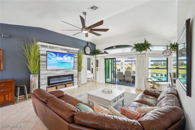 living area featuring a glass covered fireplace, visible vents, vaulted ceiling, and light tile patterned flooring