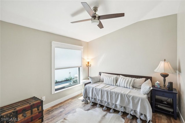 bedroom with lofted ceiling, ceiling fan, baseboards, and wood finished floors