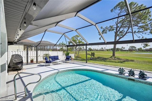 view of swimming pool featuring glass enclosure, fence, a yard, a fenced in pool, and a patio area