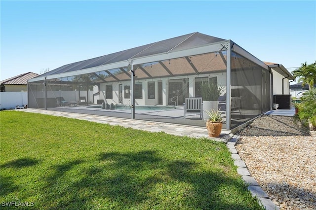 back of property with a lawn, a patio area, a lanai, and an outdoor pool