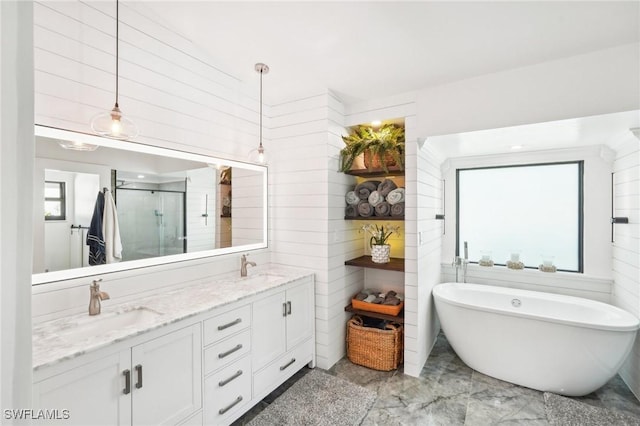 bathroom featuring a stall shower, a freestanding tub, a sink, and double vanity