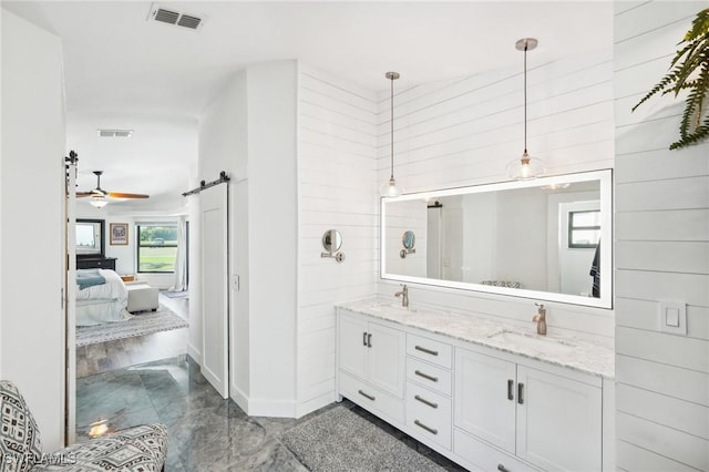 bathroom with double vanity, a sink, visible vents, and connected bathroom