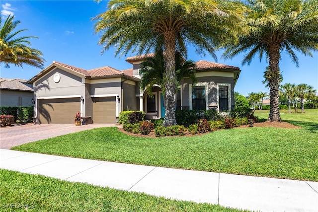 mediterranean / spanish-style home featuring a garage and a front yard