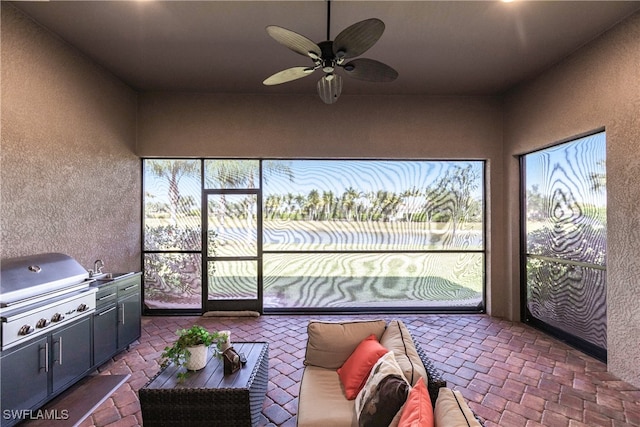 sunroom with ceiling fan and sink