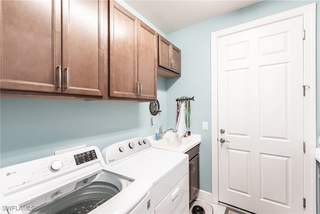 laundry room featuring tile patterned flooring, sink, washing machine and clothes dryer, and cabinets