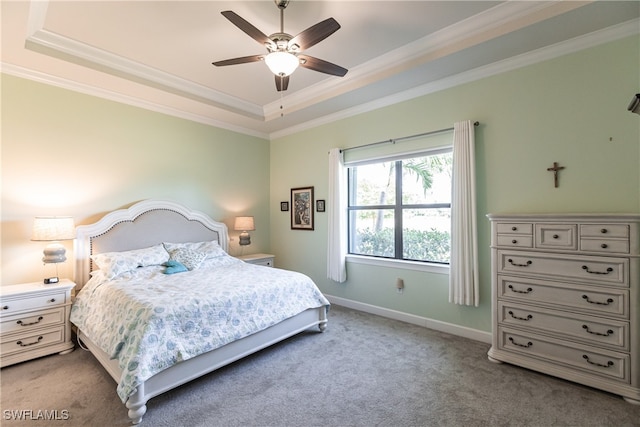 bedroom with ceiling fan, ornamental molding, a tray ceiling, and carpet flooring