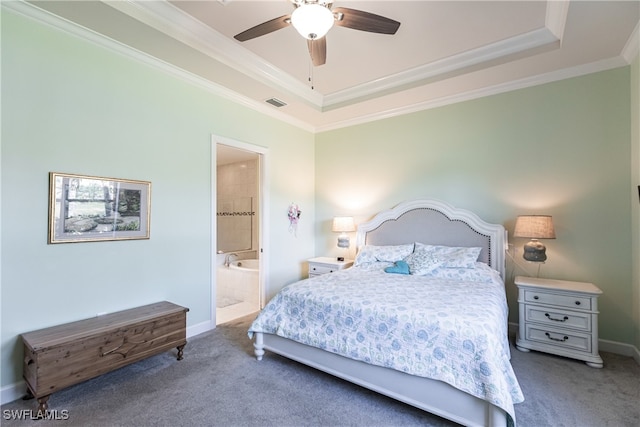 carpeted bedroom featuring ceiling fan, ornamental molding, a tray ceiling, and ensuite bathroom