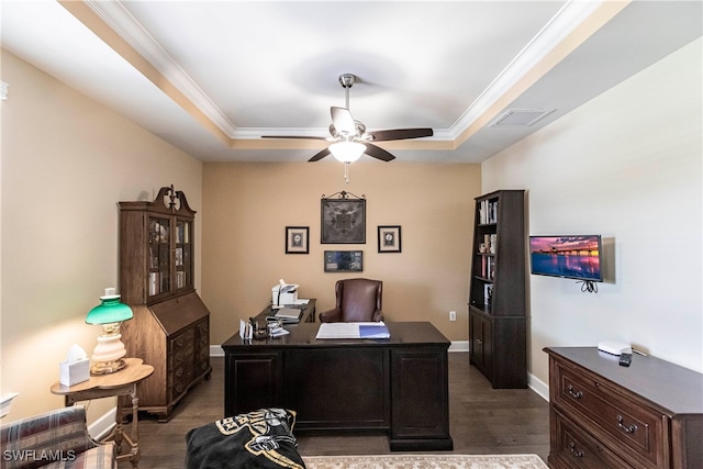 home office with crown molding, a tray ceiling, dark wood-type flooring, and ceiling fan