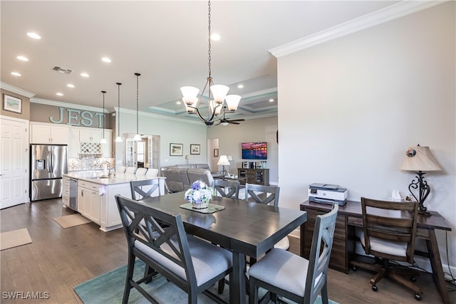 dining room featuring ornamental molding, sink, a chandelier, and dark wood-type flooring