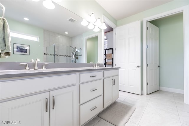 bathroom with walk in shower, vanity, and tile patterned floors