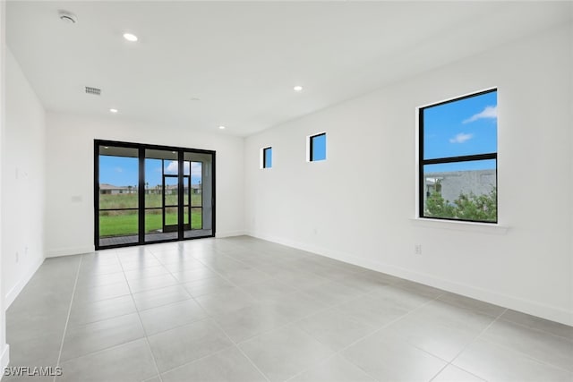 tiled spare room featuring plenty of natural light