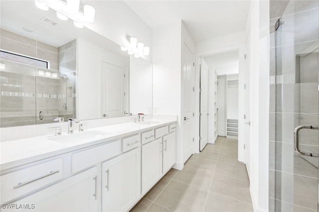 bathroom with walk in shower, vanity, and tile patterned floors