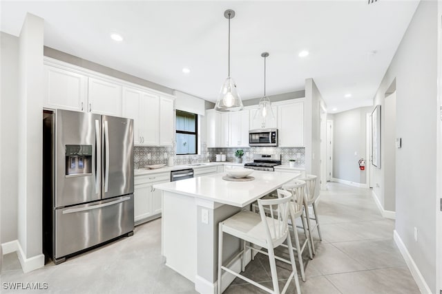 kitchen with white cabinetry, tasteful backsplash, pendant lighting, stainless steel appliances, and a center island