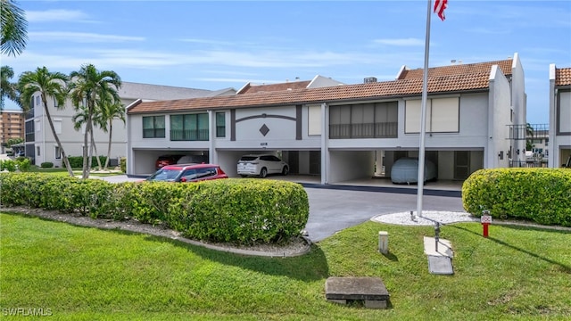 rear view of property with a carport and a lawn