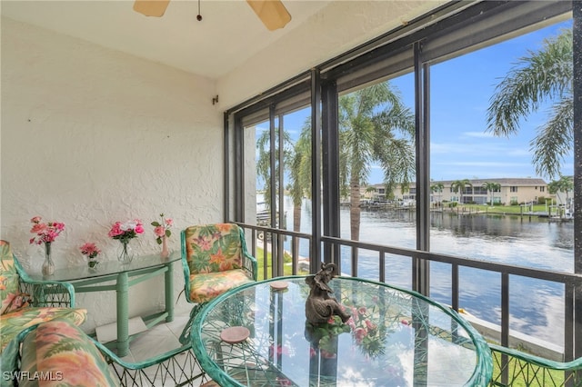 unfurnished sunroom with a water view and ceiling fan