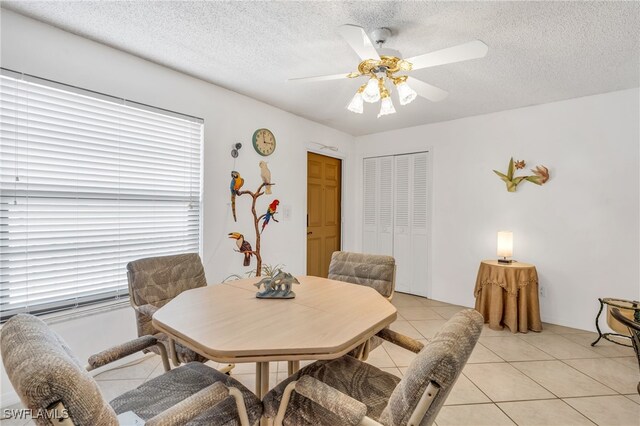 tiled dining room featuring a textured ceiling and ceiling fan