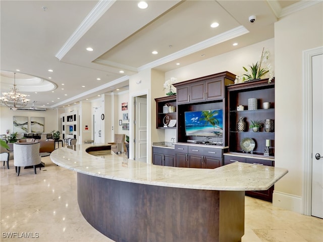 bar with light stone countertops, ornamental molding, dark brown cabinets, a raised ceiling, and a chandelier