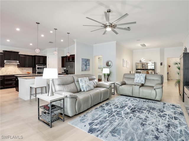 tiled living room with ceiling fan and crown molding