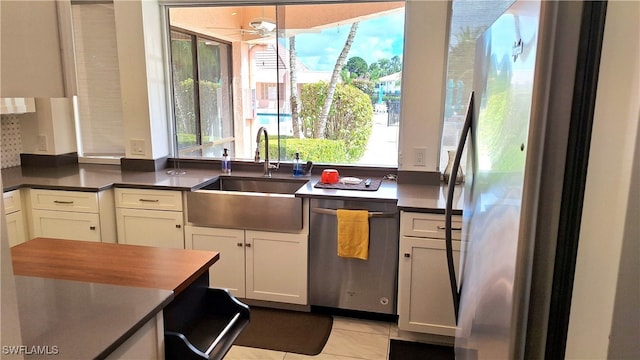 kitchen featuring white cabinetry, appliances with stainless steel finishes, sink, and light tile patterned flooring