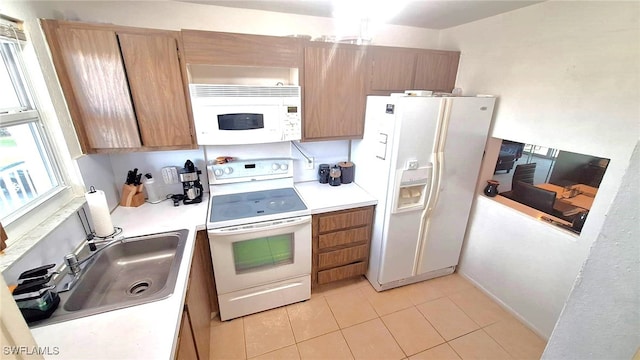 kitchen with light tile patterned flooring, white appliances, and sink