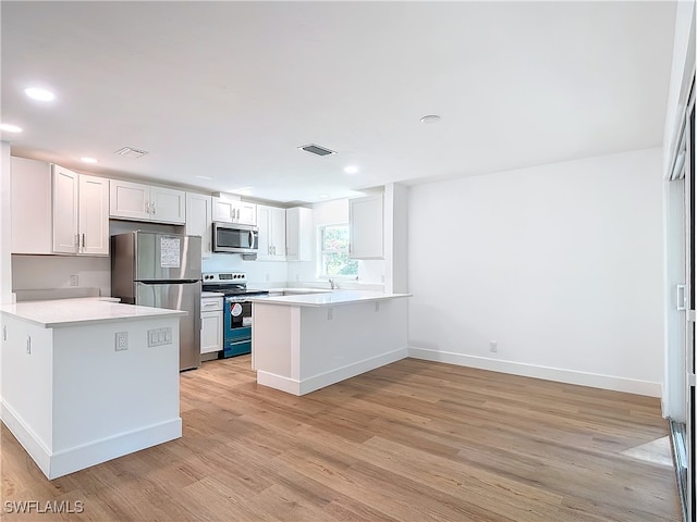 kitchen with white cabinets, kitchen peninsula, light hardwood / wood-style flooring, stainless steel appliances, and a breakfast bar