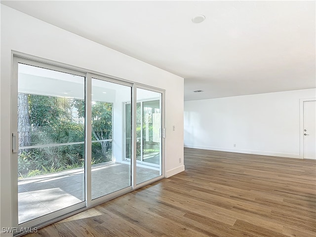 unfurnished room with hardwood / wood-style flooring