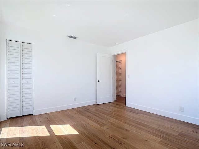 unfurnished bedroom featuring light wood-type flooring and a closet