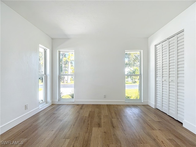 unfurnished bedroom featuring light hardwood / wood-style flooring and multiple windows