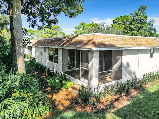 back of property with a sunroom