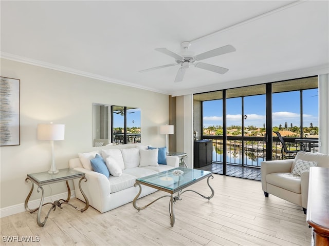 living room with ceiling fan, light wood-type flooring, ornamental molding, a wall of windows, and a water view