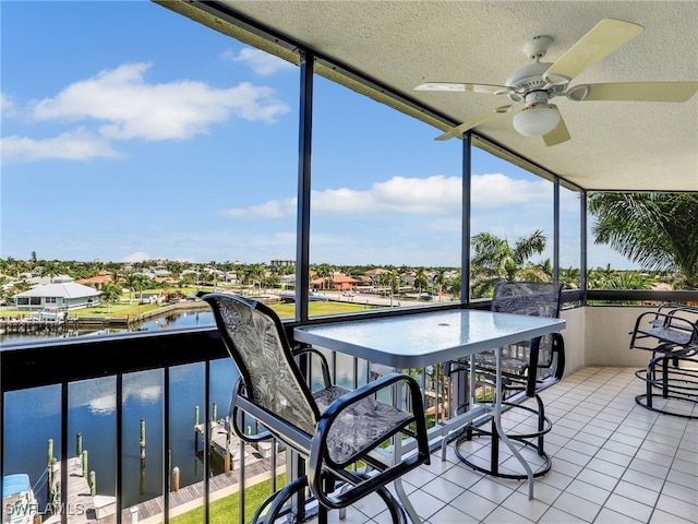 sunroom / solarium with a water view and ceiling fan