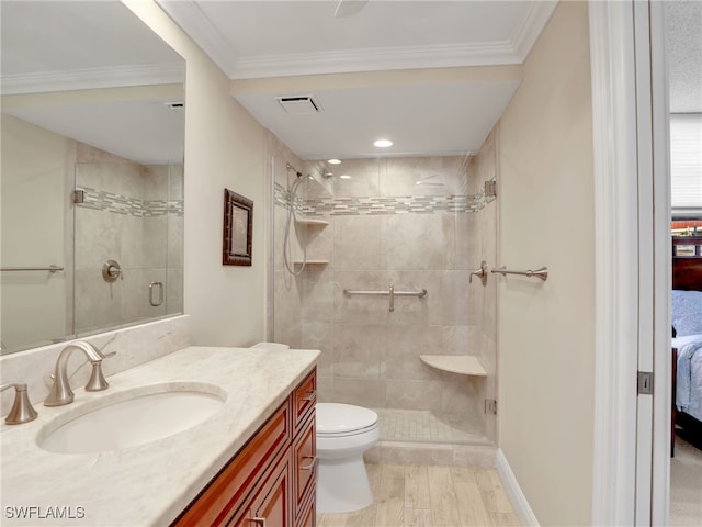 bathroom featuring wood-type flooring, a shower with door, crown molding, vanity, and toilet