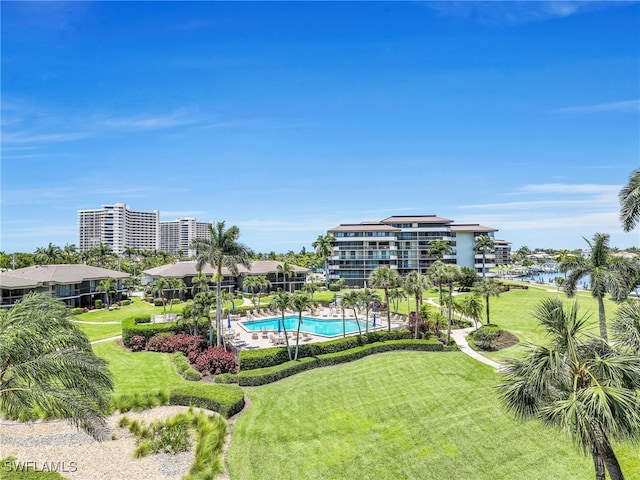 view of swimming pool with a lawn and a water view