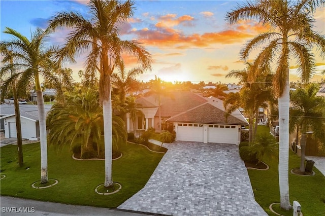 view of front of home featuring a garage, decorative driveway, and a front yard