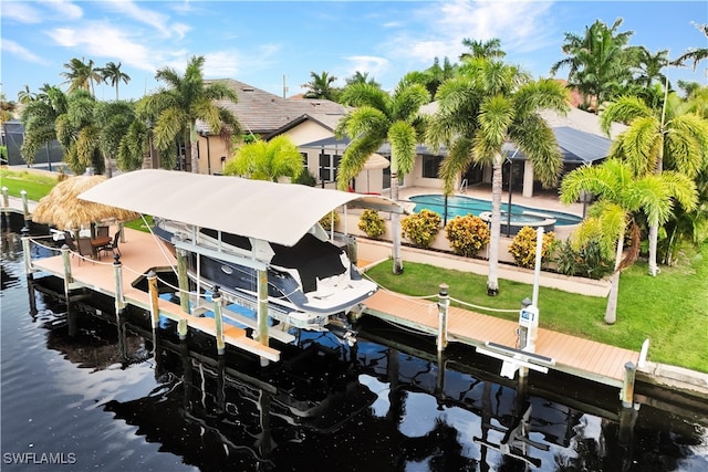 dock area featuring a water view, an outdoor pool, boat lift, and a lawn