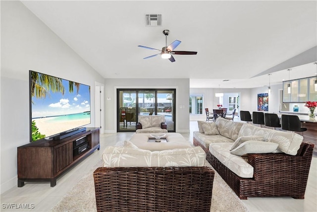 living area with high vaulted ceiling, visible vents, baseboards, and a ceiling fan