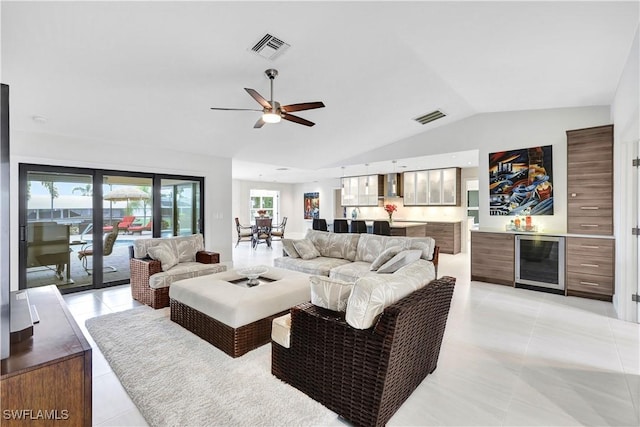 living area featuring wine cooler, visible vents, lofted ceiling, and a bar