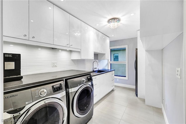 laundry area with cabinet space, washing machine and dryer, light tile patterned flooring, a sink, and baseboards