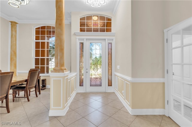 tiled entrance foyer with ornamental molding and ornate columns