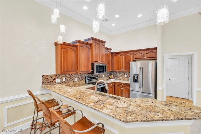 kitchen featuring kitchen peninsula, appliances with stainless steel finishes, crown molding, pendant lighting, and decorative backsplash