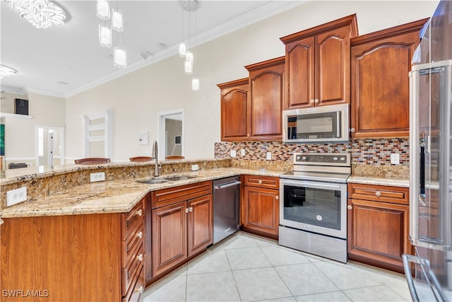 kitchen with light stone counters, sink, ornamental molding, pendant lighting, and appliances with stainless steel finishes