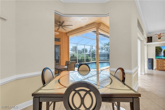 tiled dining room featuring ceiling fan and crown molding