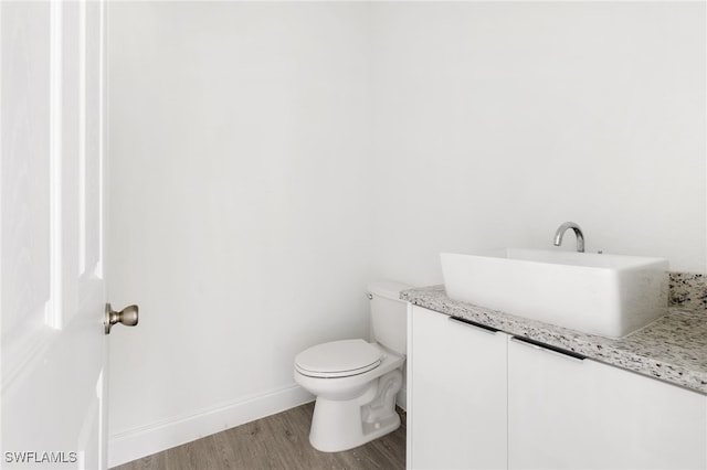 bathroom with vanity, toilet, and hardwood / wood-style flooring