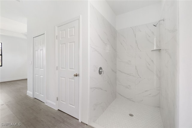 bathroom featuring hardwood / wood-style flooring and tiled shower