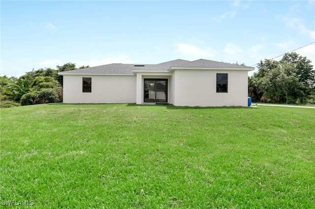 back of property featuring a lawn