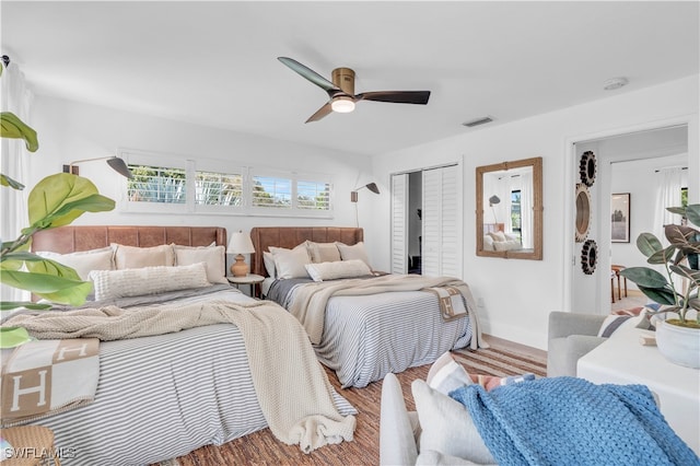 bedroom featuring hardwood / wood-style floors, ceiling fan, and a closet